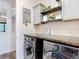 Laundry room highlighting stainless steel washer and dryer, custom cabinets, and a wood countertop at 13706 Osprey Fern Ln, Riverview, FL 33569