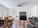 Open-concept living room with hardwood flooring, sofa, TV, ceiling fan, and natural light at 13706 Osprey Fern Ln, Riverview, FL 33569