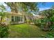 Serene backyard featuring a lush lawn, mature landscaping, and a screened lanai for outdoor living at 13872 Siena Loop, Lakewood Ranch, FL 34202