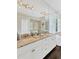 Bathroom featuring dual sinks, granite countertop, large mirror, and glass enclosed shower at 13872 Siena Loop, Lakewood Ranch, FL 34202