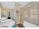 Bright bathroom featuring a standalone tub, glass shower, and a large mirror, creating a spa-like atmosphere at 13872 Siena Loop, Lakewood Ranch, FL 34202