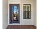 Stylish front door with glass panels and a sidelight, complemented by brick flooring at 13872 Siena Loop, Lakewood Ranch, FL 34202