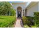Inviting front entrance with manicured landscaping, a brick walkway, and an arched portico at 13872 Siena Loop, Lakewood Ranch, FL 34202