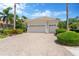 Three car garage showcasing a paver driveway, manicured landscaping, and an inviting entrance at 13872 Siena Loop, Lakewood Ranch, FL 34202