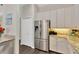 Kitchen featuring stainless steel refrigerator, granite countertops, white cabinets, and a walk-in pantry at 13872 Siena Loop, Lakewood Ranch, FL 34202