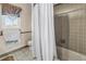 Cozy bathroom featuring a shower/tub combo, tiled walls, and a window at 1449 45Th Ne Ave, St Petersburg, FL 33703