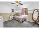 Comfortable bedroom with neutral walls, ceiling fan, carpet flooring, and warm lighting at 1449 45Th Ne Ave, St Petersburg, FL 33703