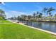 Waterfront view of a private dock with boat lift and access to a canal lined with lush landscaping and palm trees at 1449 45Th Ne Ave, St Petersburg, FL 33703