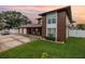 Two-story home boasting a brown exterior, arched entry, and well-manicured lawn at dusk at 1449 45Th Ne Ave, St Petersburg, FL 33703