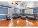 Expansive living room featuring a plush leather sectional, hardwood floors, and built-in shelves at 1449 45Th Ne Ave, St Petersburg, FL 33703