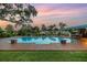 Backyard featuring an in-ground pool with a covered patio and lush, green landscaping at 1449 45Th Ne Ave, St Petersburg, FL 33703