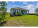 Rear exterior with green lawn and covered lanai at 1599 Running Tide Pl, Sarasota, FL 34240