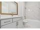Modern bathroom with white marble tiling, a bathtub, and gold fixtures at 1599 Running Tide Pl, Sarasota, FL 34240