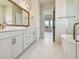 Bright bathroom featuring double sink vanity, free-standing tub, glass shower, and doorways at 1599 Running Tide Pl, Sarasota, FL 34240