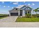 Charming two-story home with blue accents, landscaped yard, and brick paved driveway at 1599 Running Tide Pl, Sarasota, FL 34240