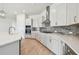 Modern kitchen featuring white cabinets, gray backsplash, and stainless steel appliances at 1599 Running Tide Pl, Sarasota, FL 34240