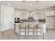 A modern kitchen showcases an island with seating, stainless steel appliances, and elegant pendant lighting at 1599 Running Tide Pl, Sarasota, FL 34240