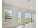 Bright living room featuring a large picture window and sliding glass doors overlooking a peaceful lake at 1599 Running Tide Pl, Sarasota, FL 34240