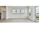 Bright, open living area featuring large windows with neighborhood views, white walls, and luxury vinyl plank floors at 1599 Running Tide Pl, Sarasota, FL 34240