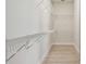 Bright walk-in closet featuring wire shelving, ample space, and light wood look flooring at 1599 Running Tide Pl, Sarasota, FL 34240