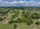 Expansive aerial view of a charming farm house with vast green fields and mature trees at 16326 Kalli Way, Dade City, FL 33523