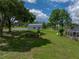 Sprawling backyard showcasing lush lawns, a fire pit area, a pool enclosure, and a storage building at 16326 Kalli Way, Dade City, FL 33523