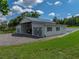Exterior of barn highlighting its metal roof, gravel driveway, open bay, and lush surrounding greenery at 16326 Kalli Way, Dade City, FL 33523