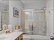 Close up of a bathroom featuring a shower and tub behind glass doors, and a single sink vanity at 16326 Kalli Way, Dade City, FL 33523