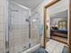 Glass enclosed shower featuring tile surround and a view into the primary bedroom at 16326 Kalli Way, Dade City, FL 33523
