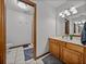 Bright bathroom featuring a wooden vanity with a marble countertop and a walk-in shower at 16326 Kalli Way, Dade City, FL 33523