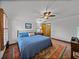 Bedroom with hardwood floors, ceiling fan, natural light, and a colorful rug at 16326 Kalli Way, Dade City, FL 33523