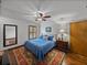 Bedroom with hardwood floors, ceiling fan, natural light, and a colorful rug at 16326 Kalli Way, Dade City, FL 33523