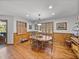 Dining room featuring hardwood floors, wood-paneled walls, shutters, and a round wooden table at 16326 Kalli Way, Dade City, FL 33523