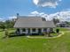A well-manicured lawn leads to a charming home with rocking chairs on the front porch at 16326 Kalli Way, Dade City, FL 33523