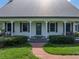 Close up of a charming front porch with inviting seating and lovely landscaping at 16326 Kalli Way, Dade City, FL 33523