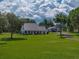 Beautiful home with manicured lawn and detached garage on a sunny day at 16326 Kalli Way, Dade City, FL 33523