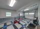 Spacious garage with diamond-patterned flooring, paneled walls, and an open garage door with windows at 16326 Kalli Way, Dade City, FL 33523