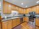 Beautiful kitchen featuring stainless steel appliances, oak cabinetry, and hardwood floors at 16326 Kalli Way, Dade City, FL 33523