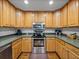 Well-lit kitchen featuring stainless steel appliances, oak cabinetry, and hardwood floors at 16326 Kalli Way, Dade City, FL 33523