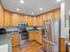 Cozy kitchen featuring wood cabinetry, stainless steel appliances and hardwood floors at 16326 Kalli Way, Dade City, FL 33523