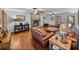 Spacious living room with hardwood floors, brick fireplace, ceiling fans, and comfortable leather furniture at 16326 Kalli Way, Dade City, FL 33523