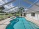 The screened in pool features a unique kidney bean shape and spa at 16326 Kalli Way, Dade City, FL 33523