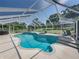View of screened-in pool featuring an attached spa, beautiful tile work, and an expansive backyard with seating areas at 16326 Kalli Way, Dade City, FL 33523