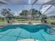 Screened-in pool featuring a spa and view of lush green backyard with lounge furniture and two umbrella-covered tables at 16326 Kalli Way, Dade City, FL 33523