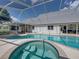 Backyard pool and spa with screened-in enclosure connected to the house at 16326 Kalli Way, Dade City, FL 33523