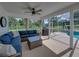 Inviting screened-in porch featuring comfortable seating and an outdoor grill overlooking a sparkling pool at 16326 Kalli Way, Dade City, FL 33523