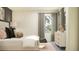 Cozy bedroom with a cushioned headboard, natural light from window, and modern dresser at 17244 Tortoise Crown Blvd, Land O Lakes, FL 34638