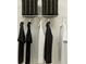 Organized closet with hanging rods, black and white clothes, and upper storage baskets at 17244 Tortoise Crown Blvd, Land O Lakes, FL 34638