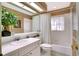 Bathroom features vanity with a sink, bathtub with shower and decorative wallpaper at 17321 Oak Ledge Dr, Lutz, FL 33549