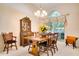 Traditional dining room with hardwood table, cabinet, chandelier, and large arched window at 17321 Oak Ledge Dr, Lutz, FL 33549